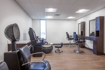 a salon room with a variety of chairs and a window